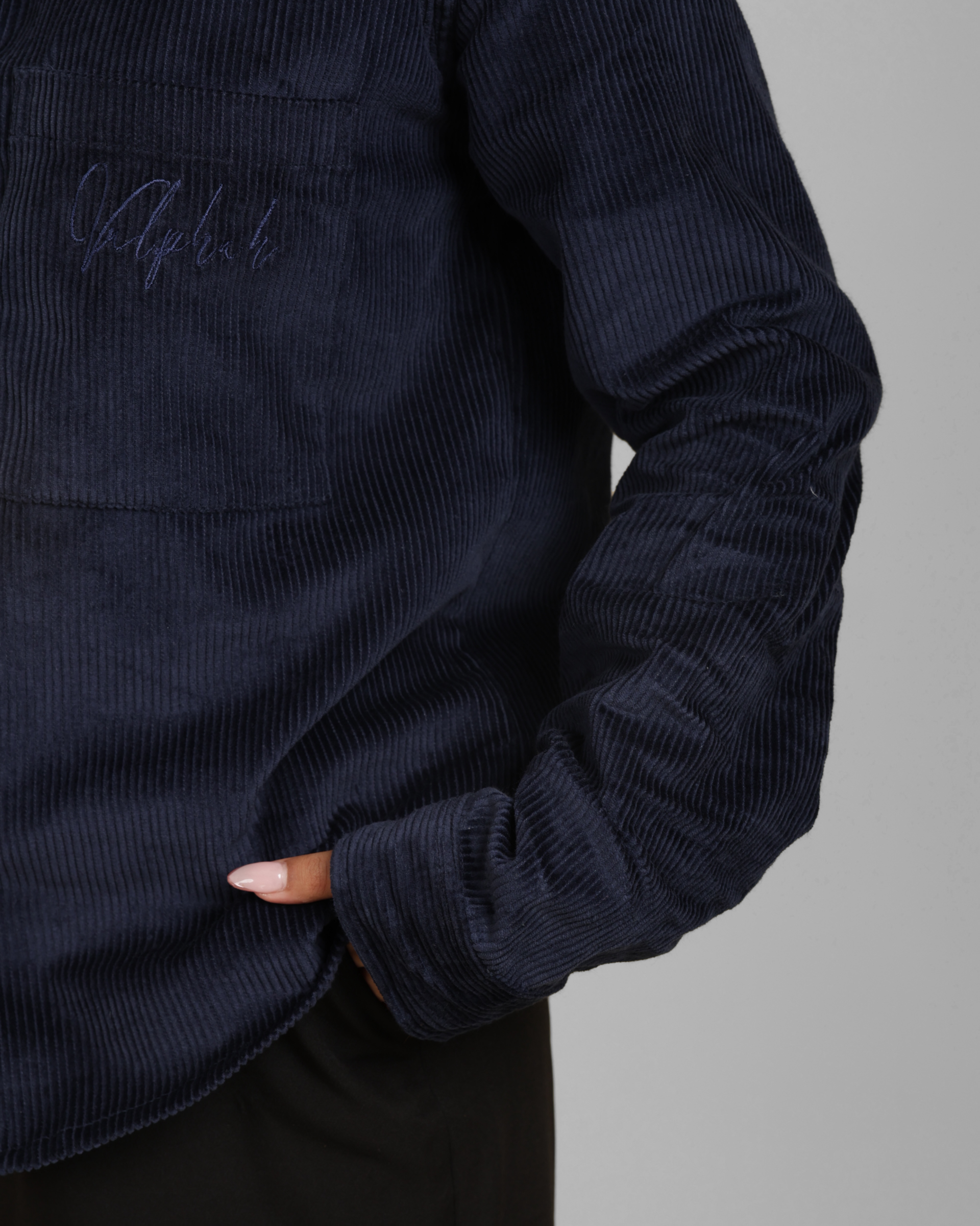 Navy corduroy shirt with brand logo on a gray background