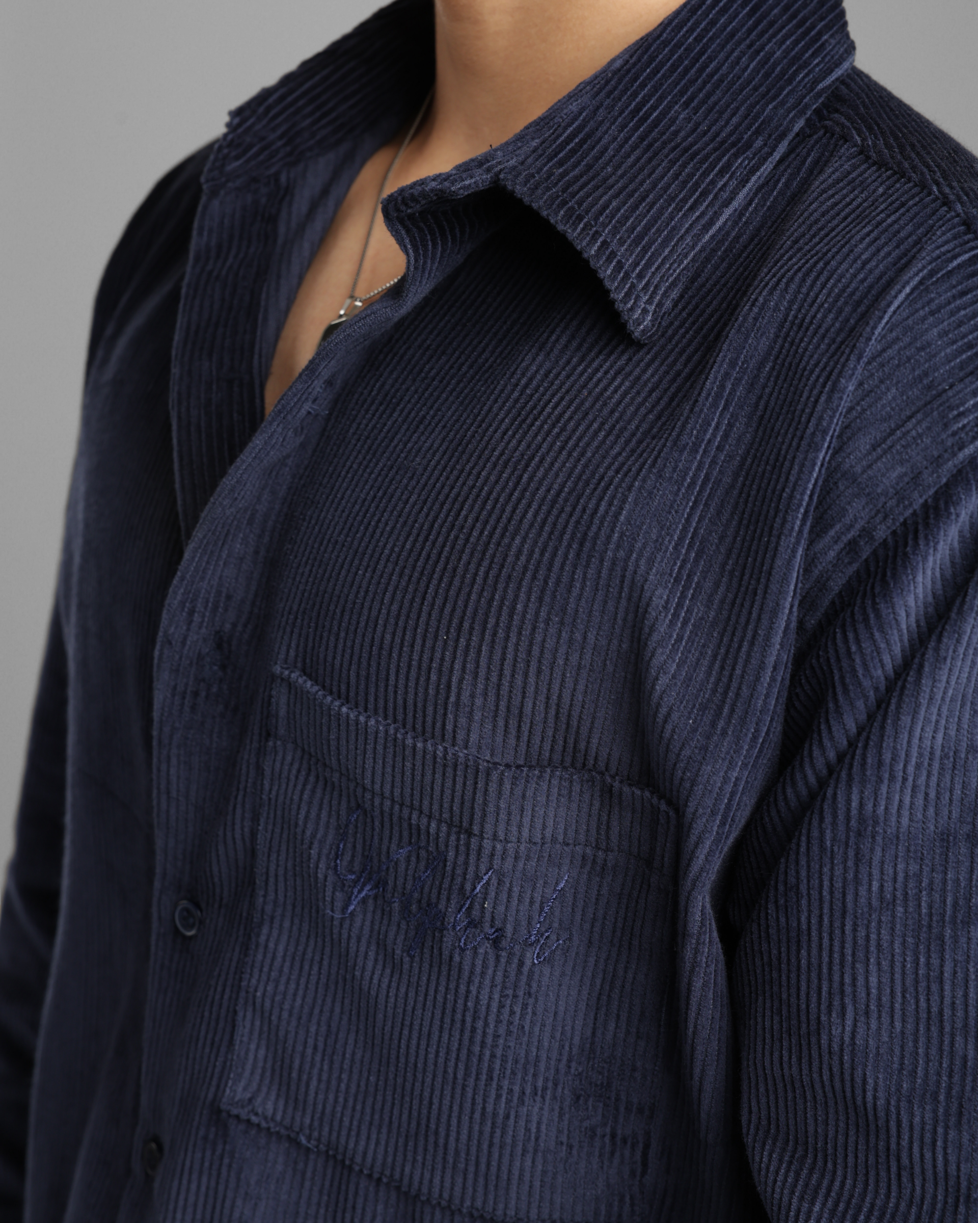 Navy blue corduroy shirt with Embroidery on a gray background