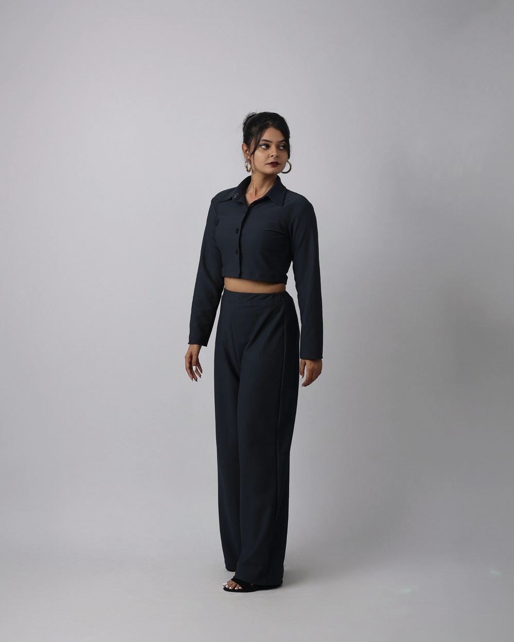Person wearing a charcoal blue outfit on a plain background