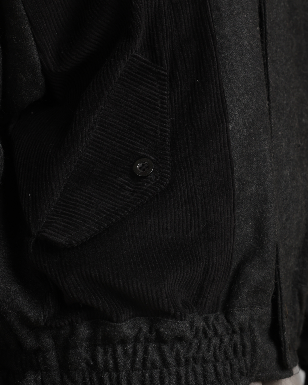 Close-up of a dark textured fabric with a button detail