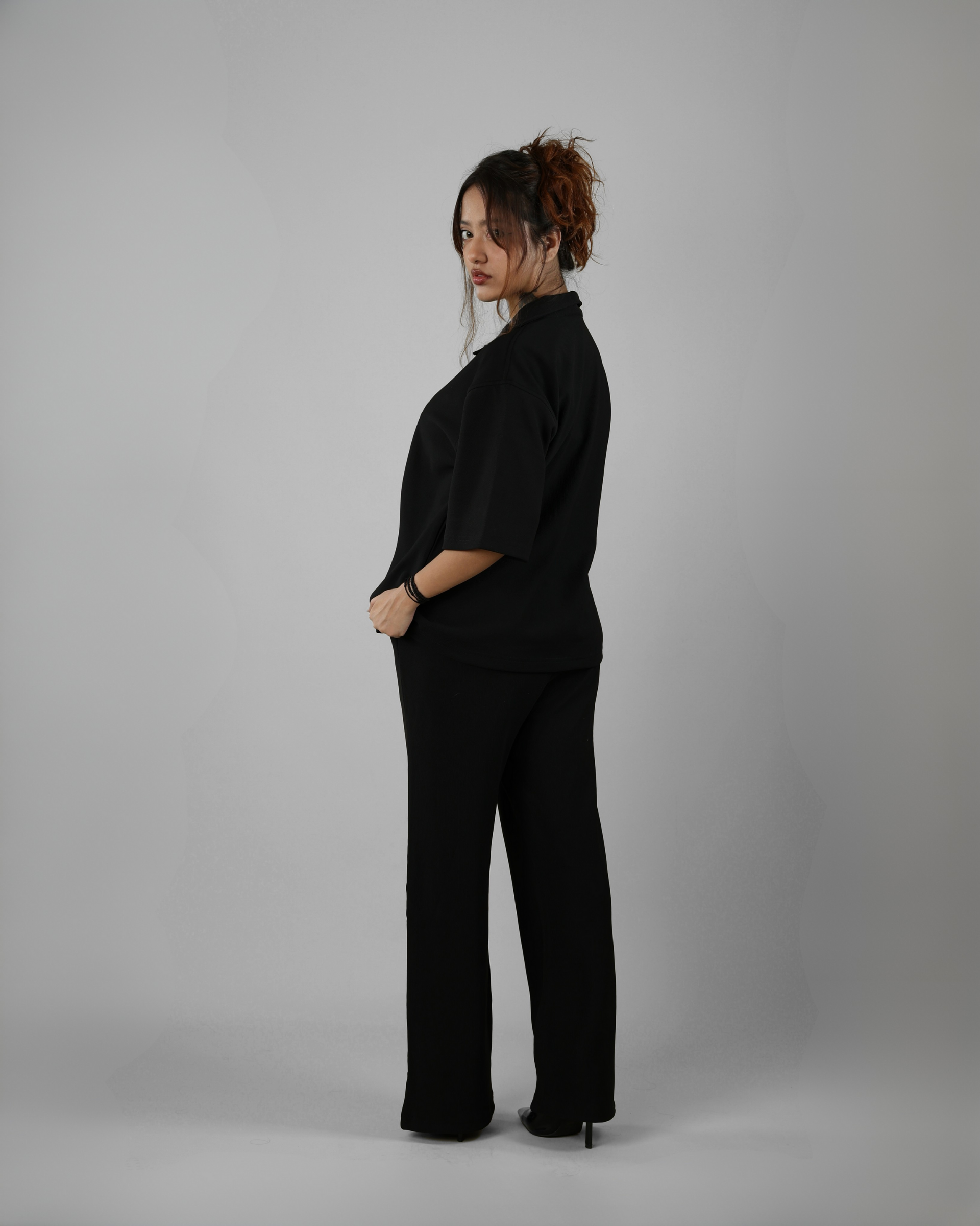Person wearing a black outfit on a plain background