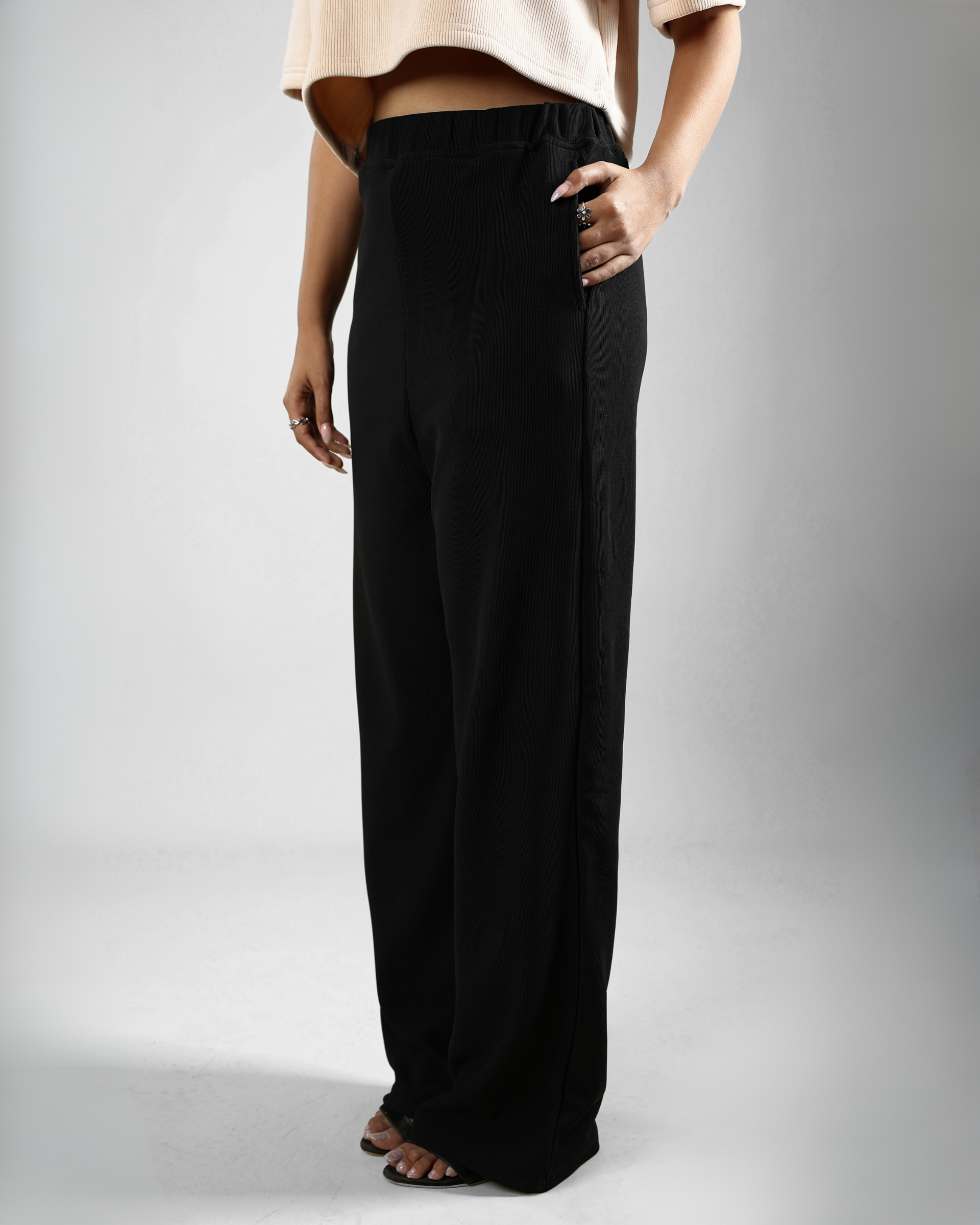 Person wearing black wide-leg pants on a plain background