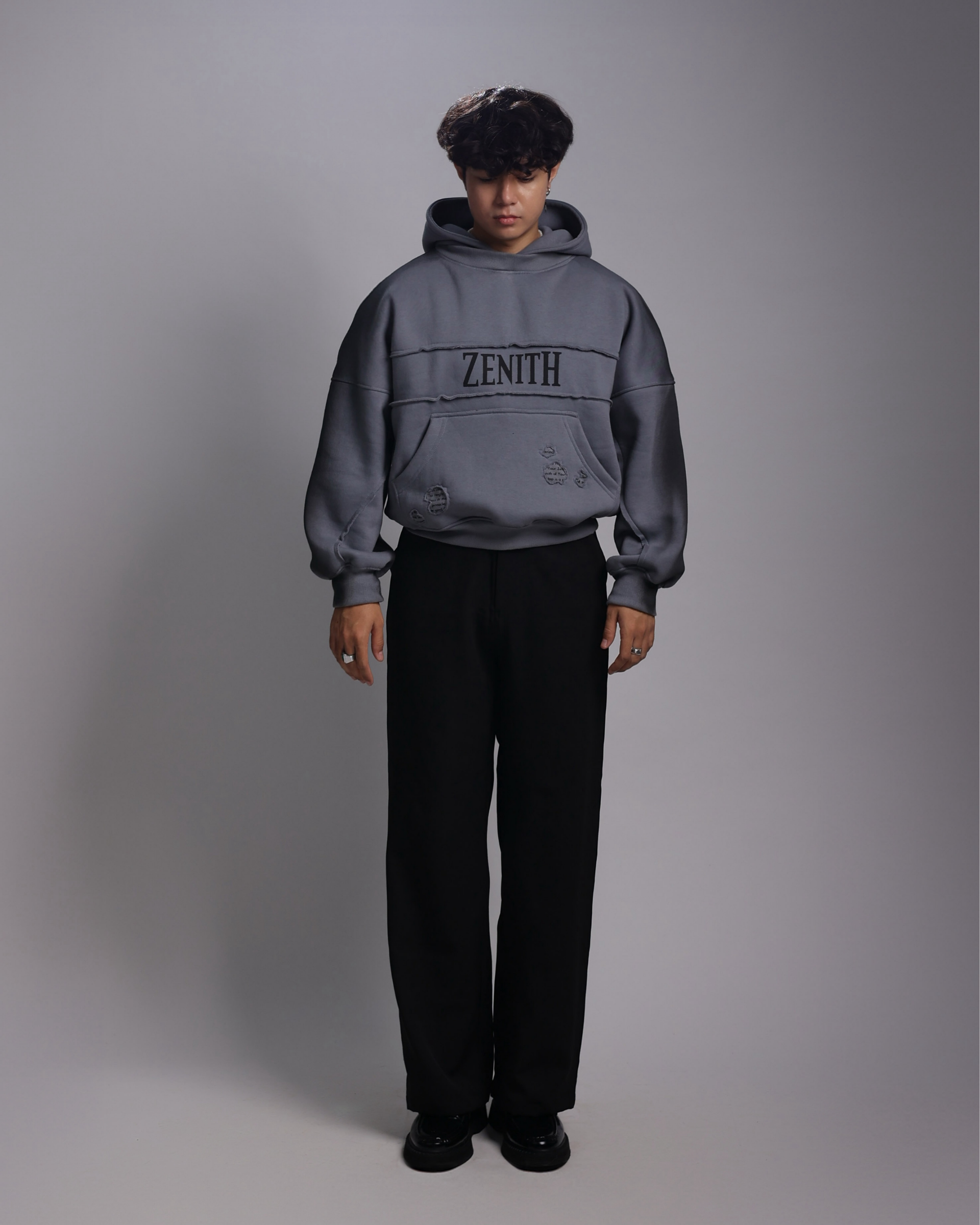 Person wearing a gray hoodie with 'ZENITH' branding on a gray background